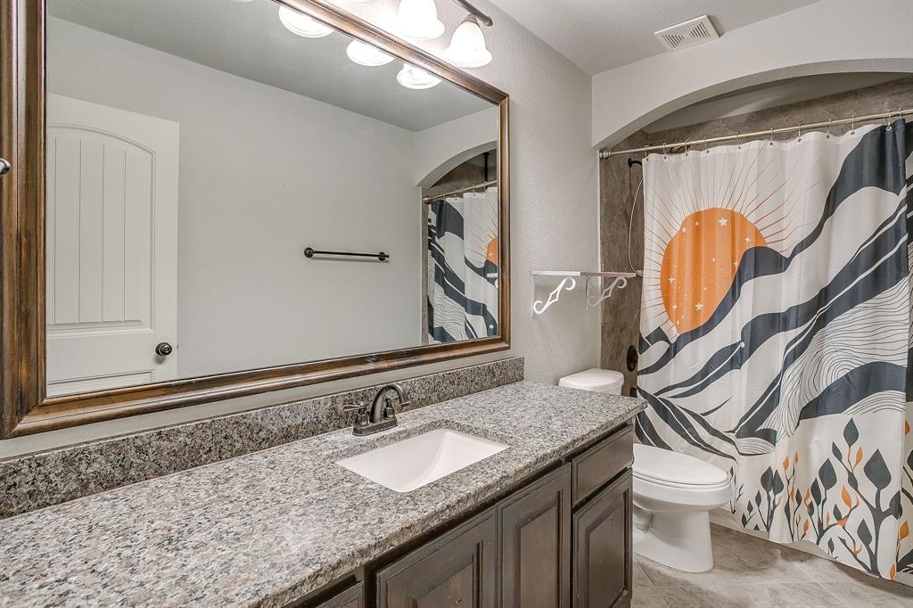 329 Madison Street Burleson, TX 76028 - Photo 27 of 40 a bathroom with a granite countertop toilet sink and mirror