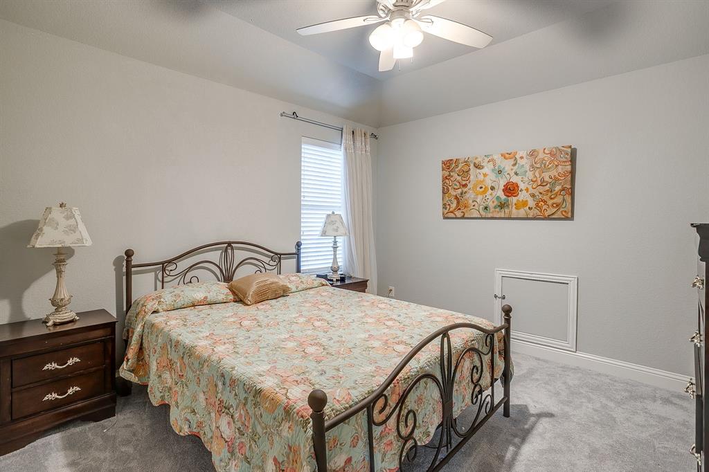 329 Madison Street Burleson, TX 76028 - Photo 28 of 40 a bedroom with a bed and a chandelier