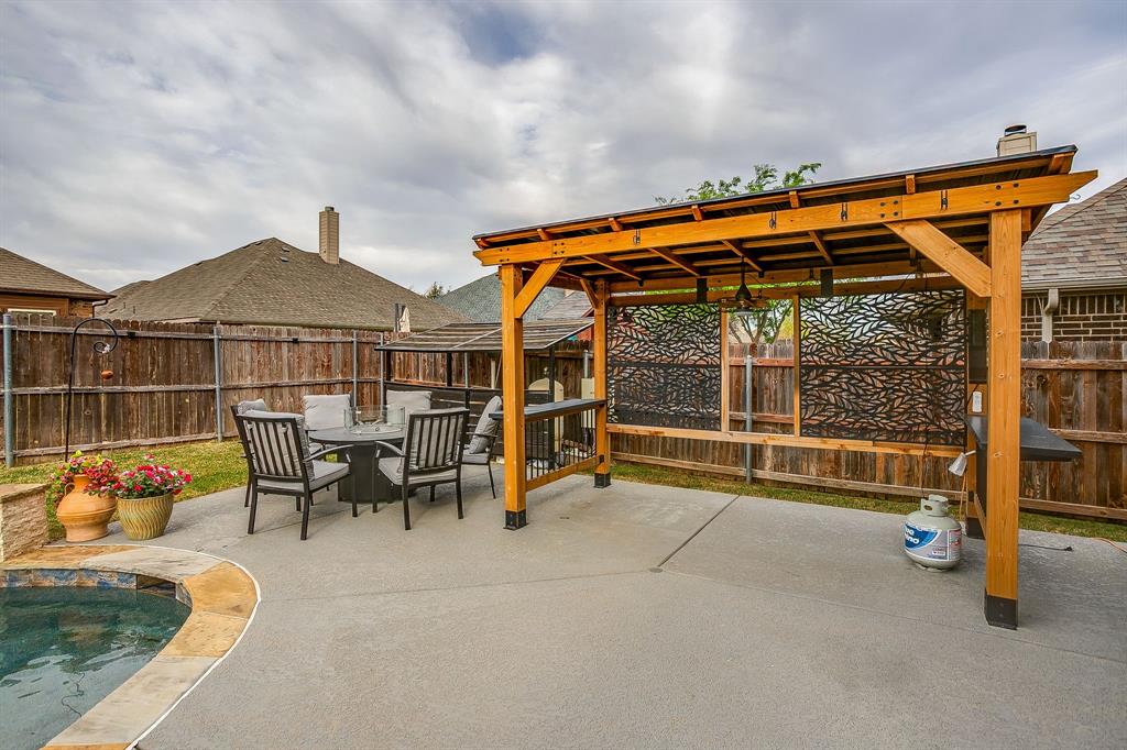 329 Madison Street Burleson, TX 76028 - Photo 40 of 40 a view of a chairs and table in the back yard of the house