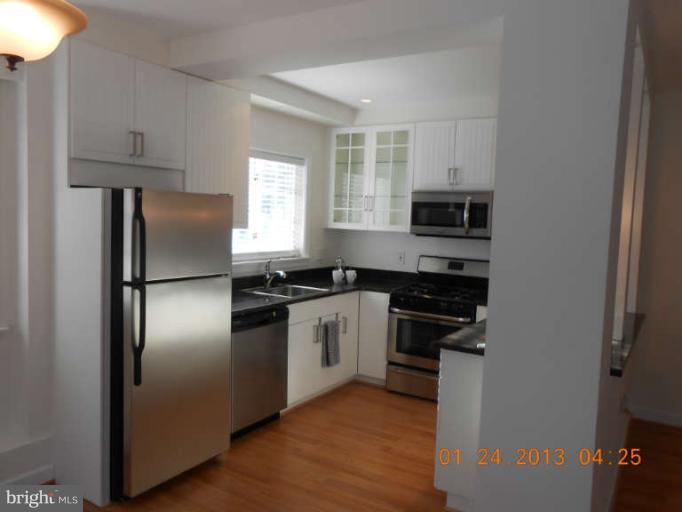3203 Gunston Road, Unit 11032 Alexandria, VA 22302 - Photo 4 of 20 a kitchen with stainless steel appliances granite countertop a refrigerator a stove a sink and a microwave