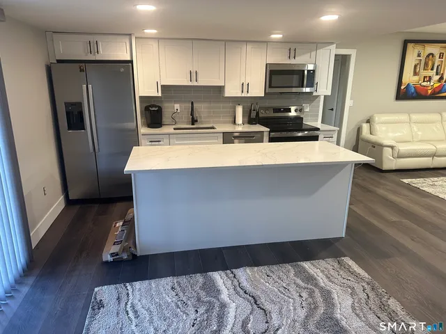 a kitchen with stainless steel appliances a refrigerator and a stove top oven