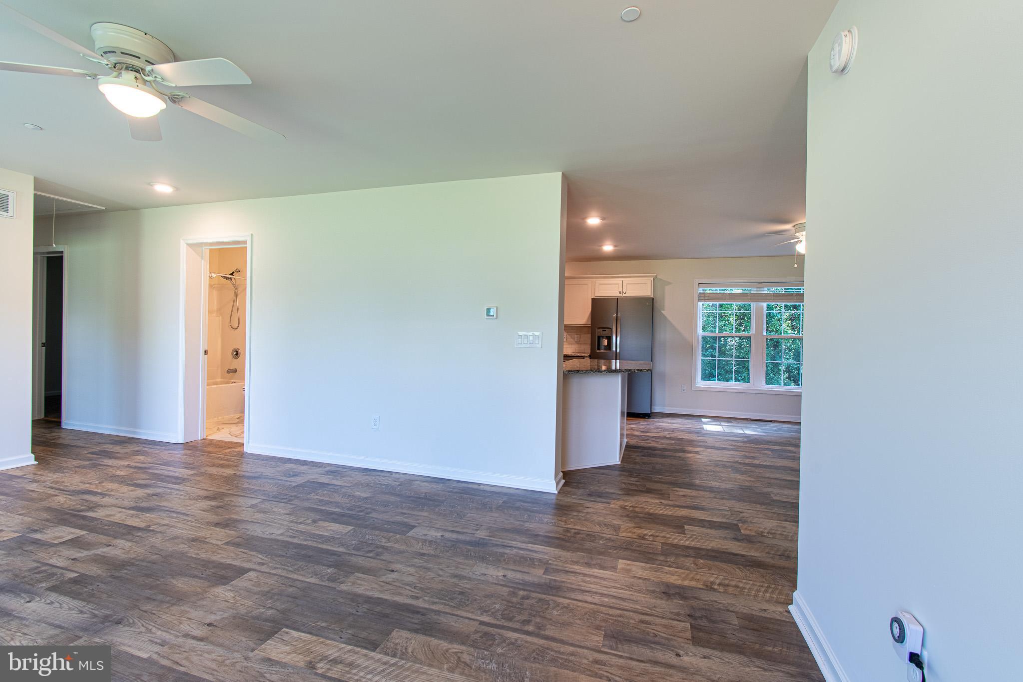 21869 Albie Road Sherwood, MD 21665 - Photo 12 of 38 a view of a hallway with wooden floor and a kitchen