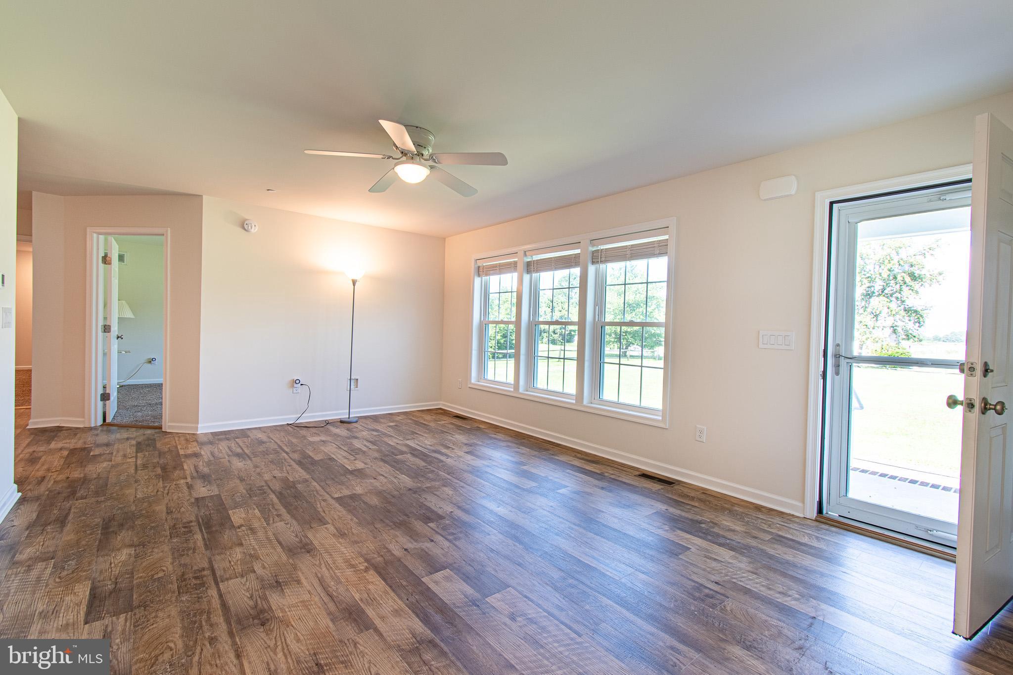 21869 Albie Road Sherwood, MD 21665 - Photo 15 of 38 a view of an empty room with a window and wooden floor