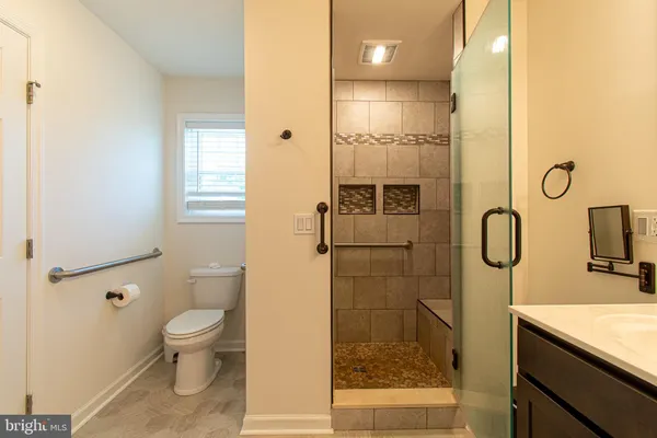 a bathroom with a granite countertop sink a toilet and shower