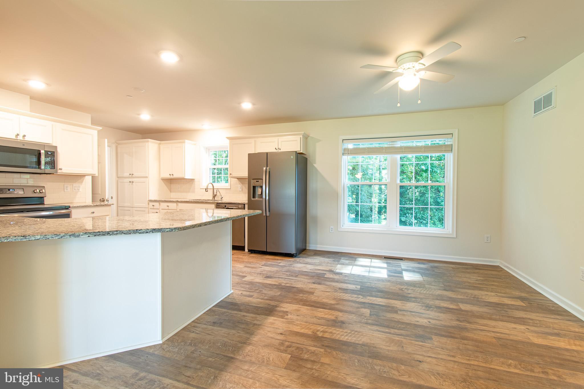 21869 Albie Road Sherwood, MD 21665 - Photo 7 of 38 a large kitchen with kitchen island a sink stainless steel appliances and cabinets