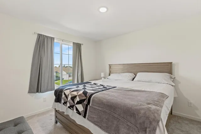 a bedroom with a bed and a window