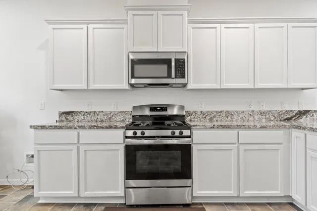 a kitchen with white cabinets and stainless steel appliances