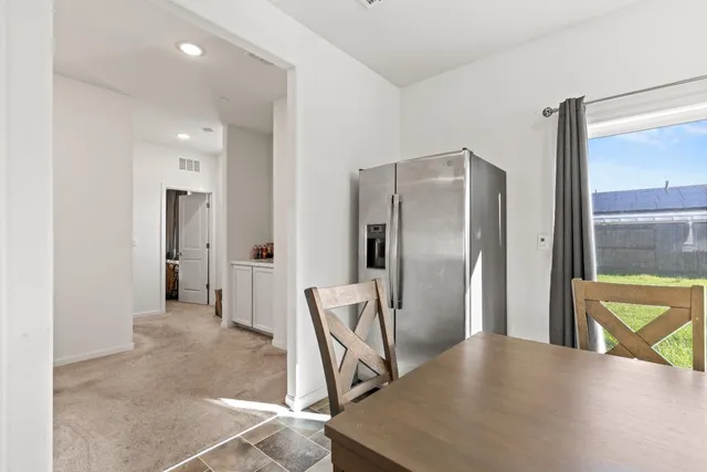 a view of a refrigerator in kitchen and a window