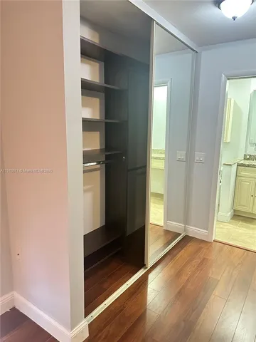 a view of a room with wooden floor and ceiling fan
