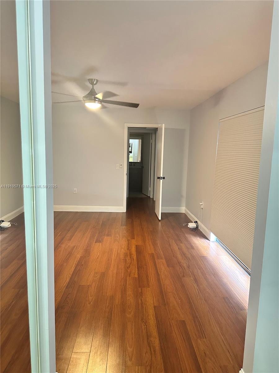9156 Southwest 23rd Street, Unit D Davie, FL 33324 - Photo 12 of 14 a view of a room with wooden floor and ceiling fan