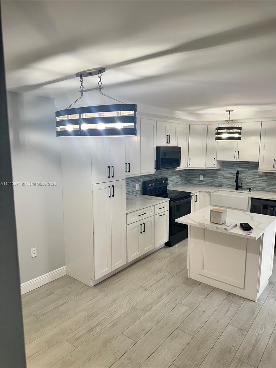 9156 Southwest 23rd Street, Unit D Davie, FL 33324 - Photo 5 of 14 a kitchen with stainless steel appliances a white stove top oven a sink and a refrigerator