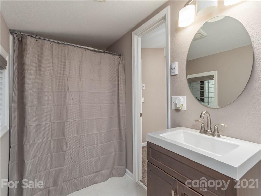 79 Susan Drive Maggie Valley, NC 28751 - Photo 15 of 17 a bathroom with a sink a mirror and a shower curtain