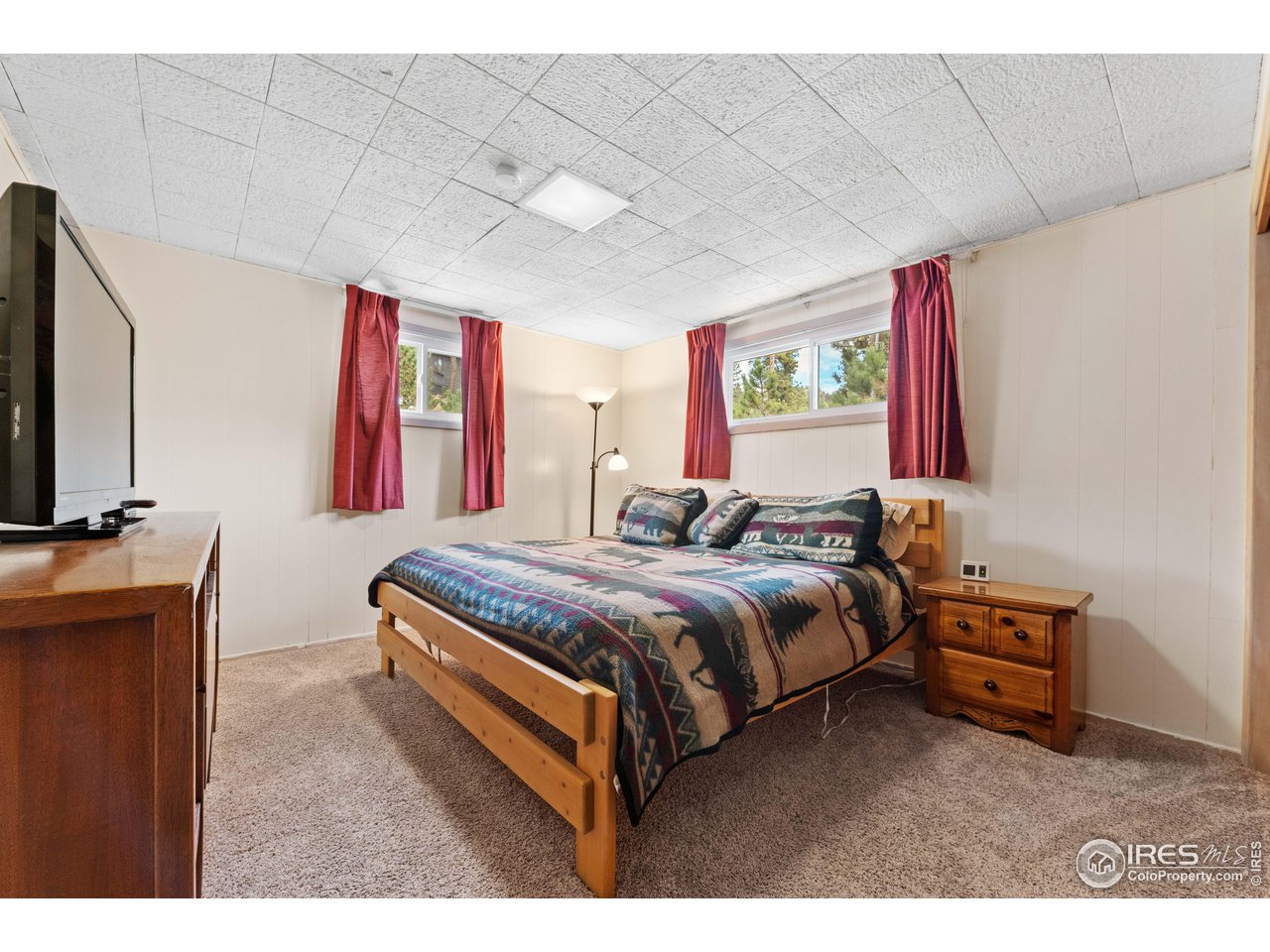 654 Hemlock Drive Lyons, CO 80540 - Photo 14 of 32 a bedroom with a bed and a flat screen tv