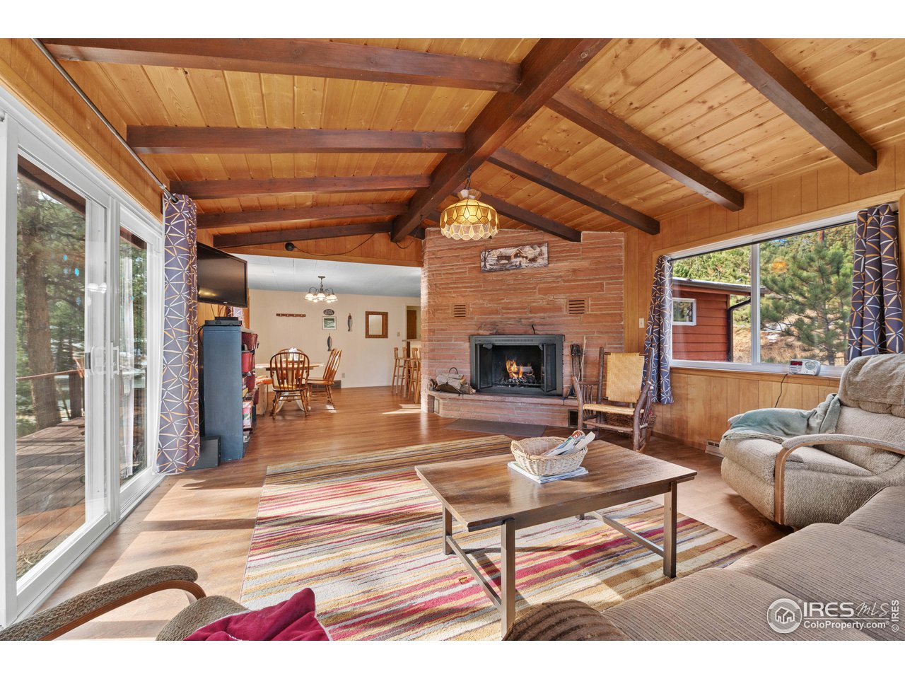 654 Hemlock Drive Lyons, CO 80540 - Photo 2 of 32 a living room with furniture a fireplace and a table
