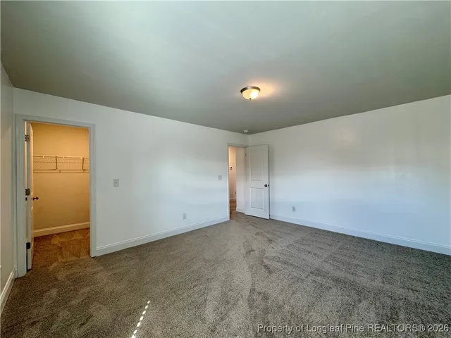 an empty room with closet and windows