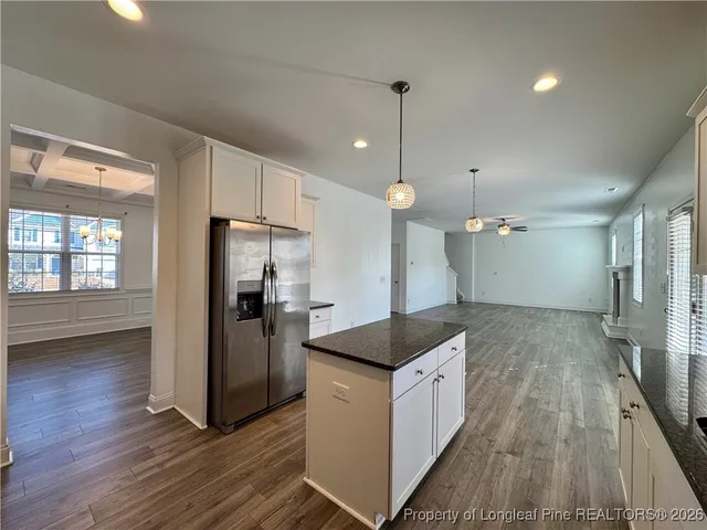 a kitchen with a refrigerator a sink and wooden floor
