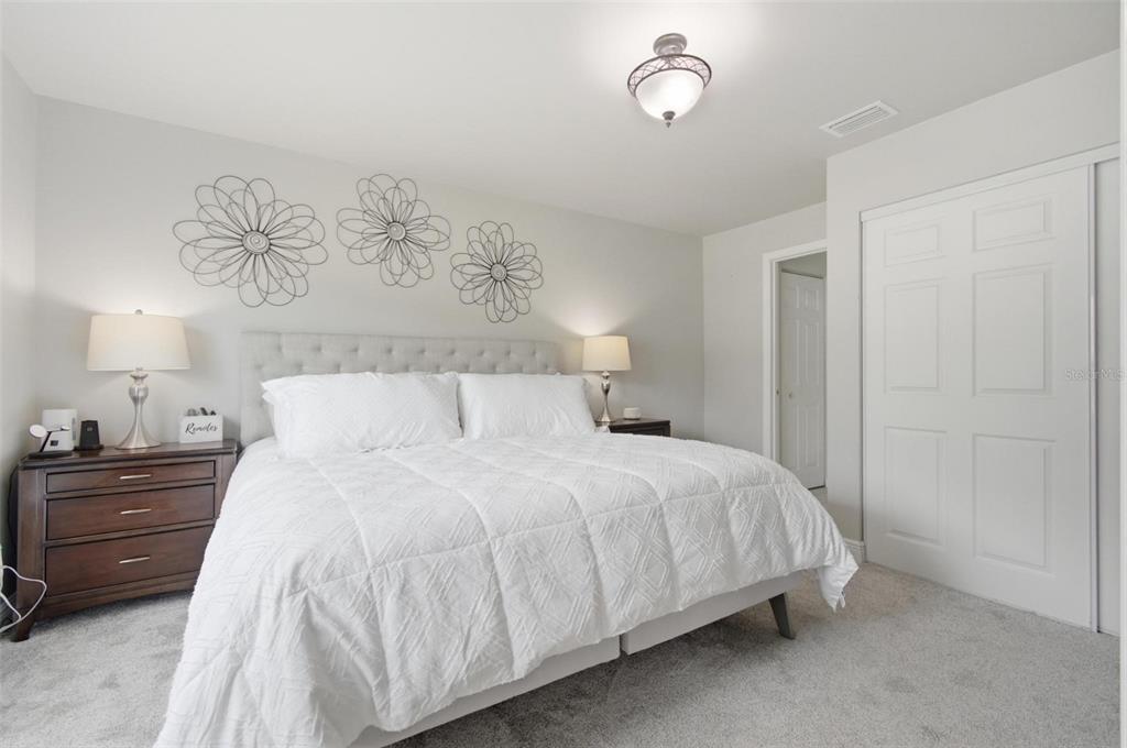 13 Slowdrift Palm Coast, FL 32164 - Photo 15 of 58 a bedroom with a bed and a painting on the wall