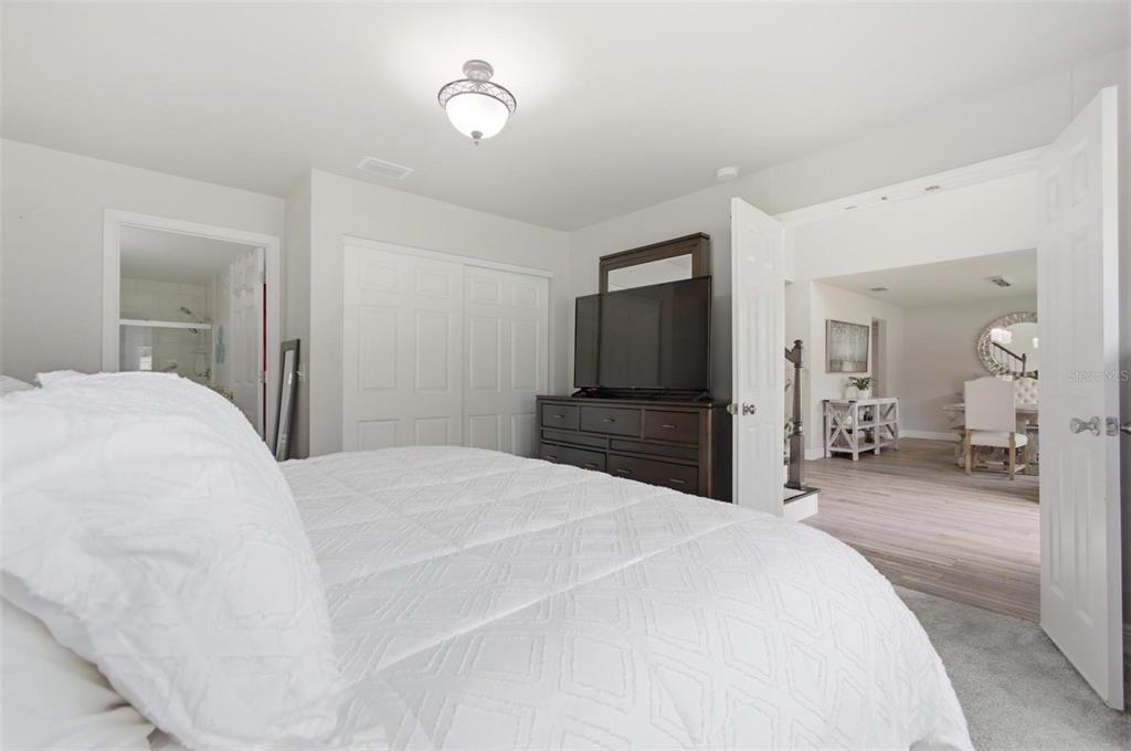 13 Slowdrift Palm Coast, FL 32164 - Photo 16 of 58 a bedroom with a bed and a large mirror