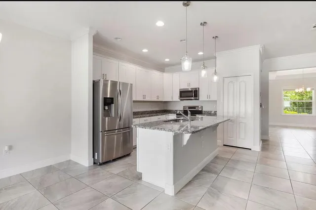 a large kitchen with a refrigerator and a sink