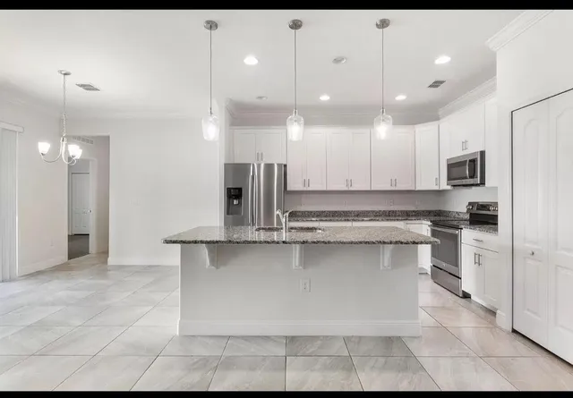 a kitchen with kitchen island a sink stainless steel appliances and cabinets