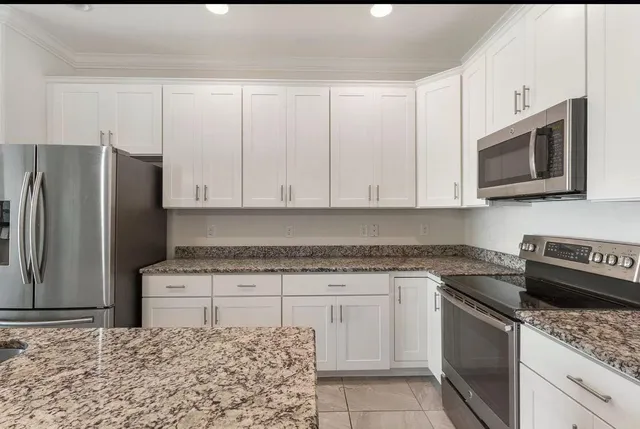 a kitchen with stainless steel appliances granite countertop a stove a sink and a microwave