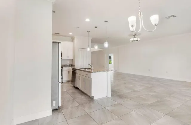 a large white kitchen with a sink a refrigerator and a stove