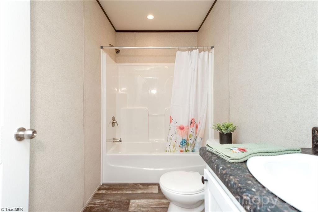 1975 Carl Fox Road Taylorsville, NC 28681 - Photo 21 of 33 a bathroom with a granite countertop bathtub sink vanity mirror and toilet