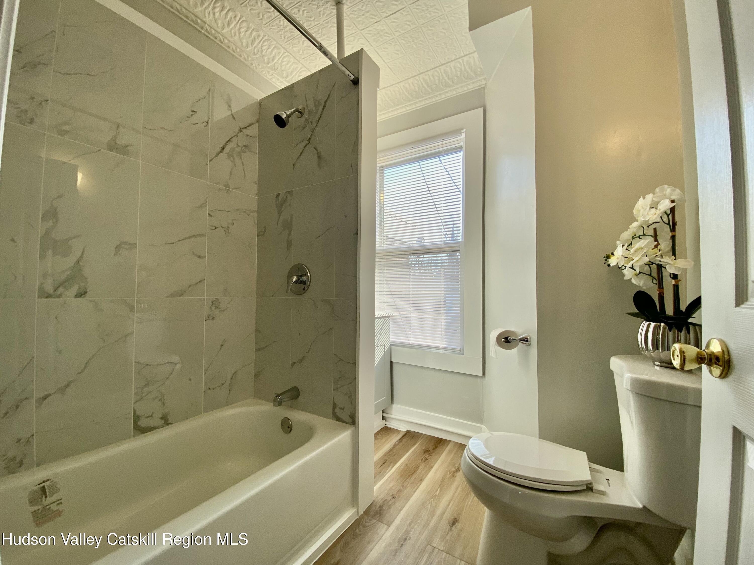 91 Broadway, Unit #2 Kingston, NY 12401 - Photo 12 of 14 a bathroom with a sink a toilet and shower