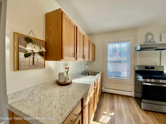 a kitchen with granite countertop a sink a stove and wooden floor