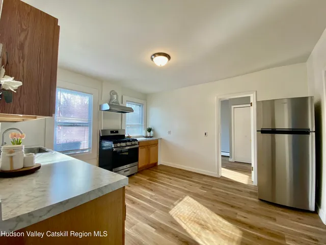 a kitchen with stainless steel appliances granite countertop a refrigerator a stove and a sink