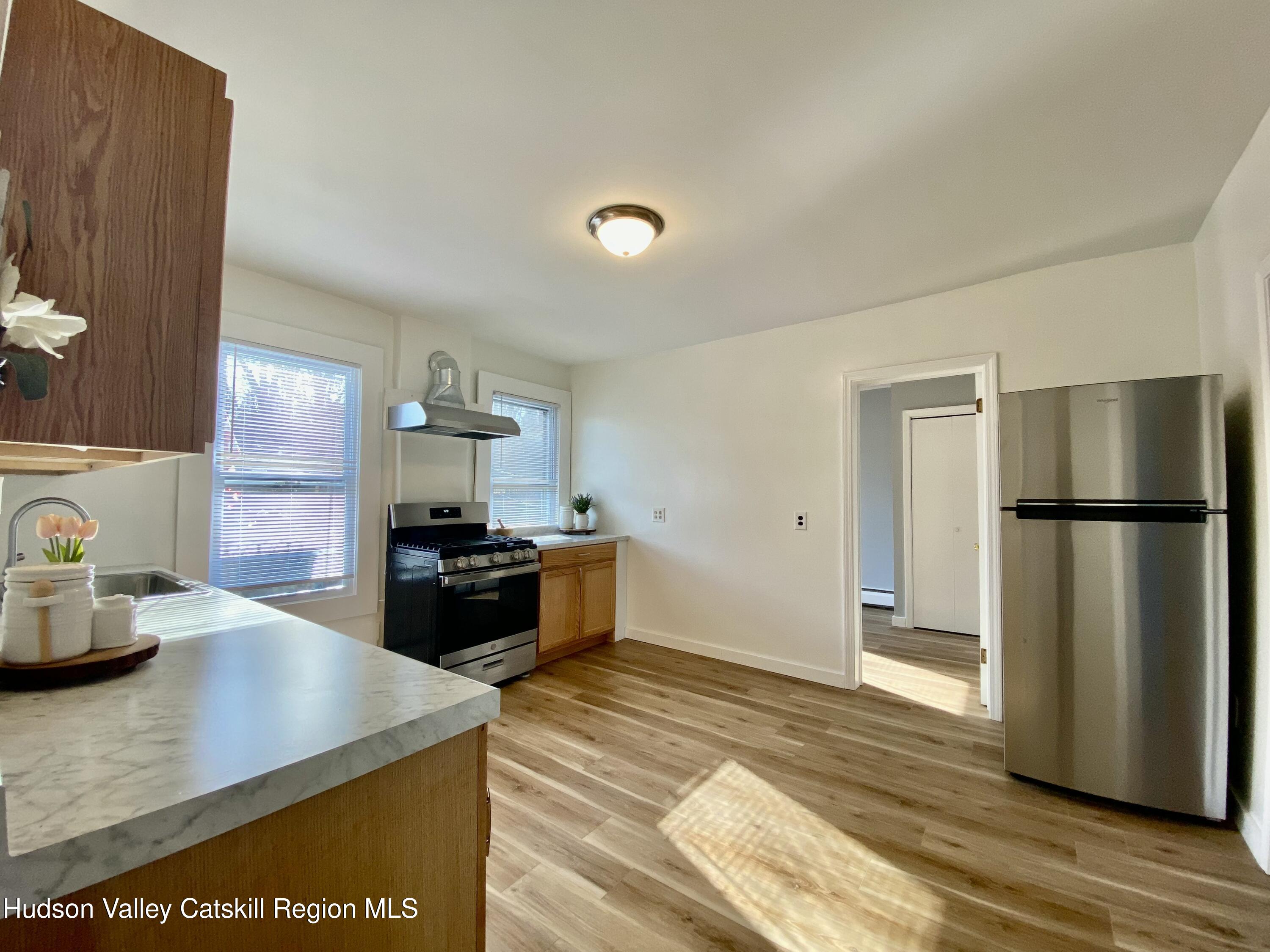 91 Broadway, Unit #2 Kingston, NY 12401 - Photo 6 of 14 a kitchen with stainless steel appliances granite countertop a refrigerator a stove and a sink