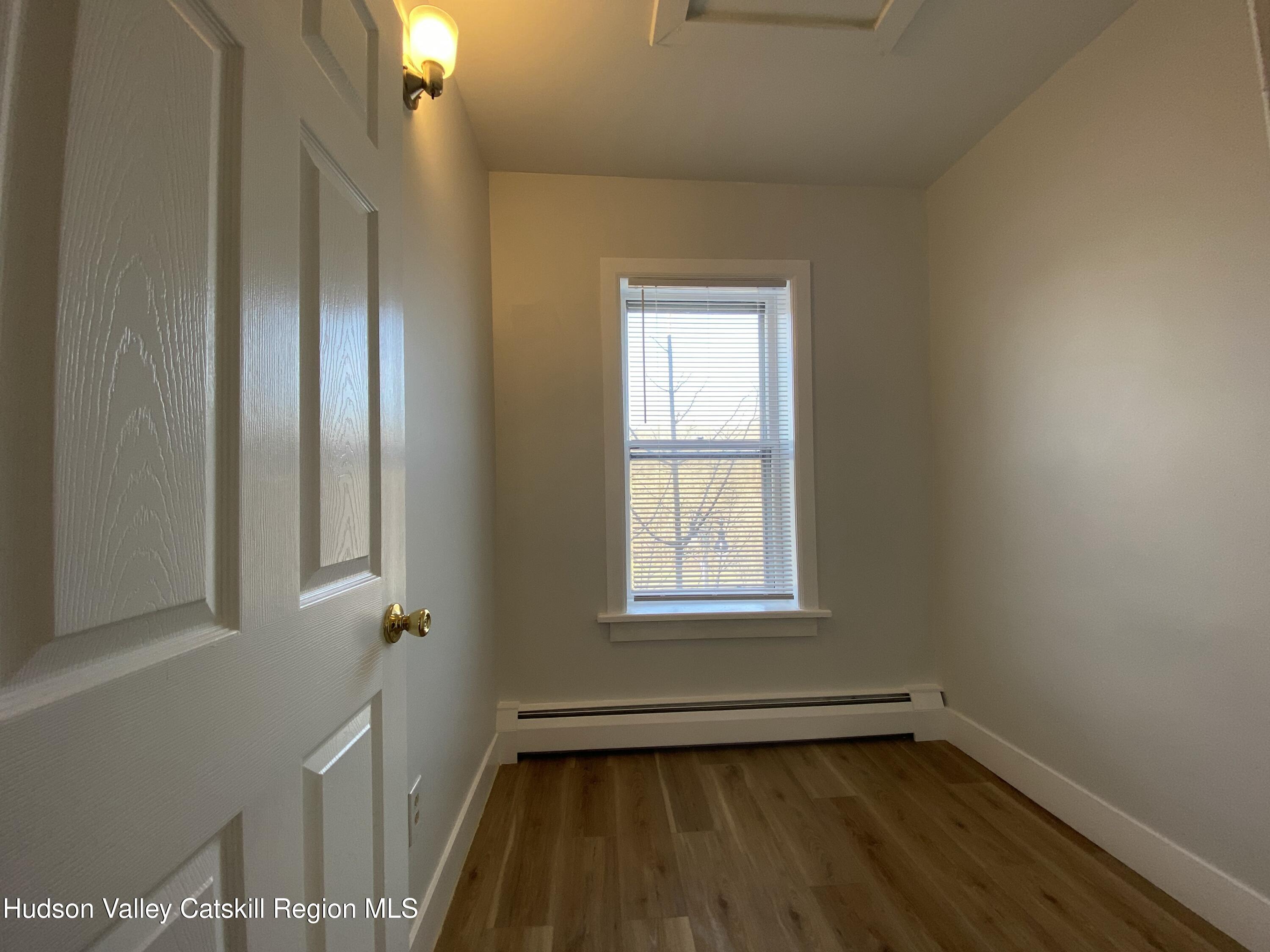 91 Broadway, Unit #2 Kingston, NY 12401 - Photo 10 of 14 an empty room with wooden floor and windows