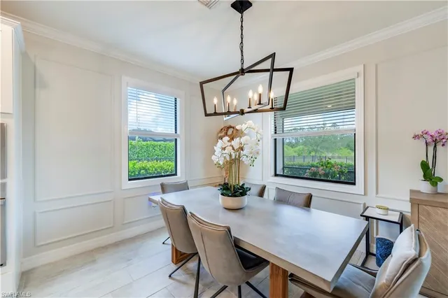 a dining room with furniture a chandelier and wooden floor