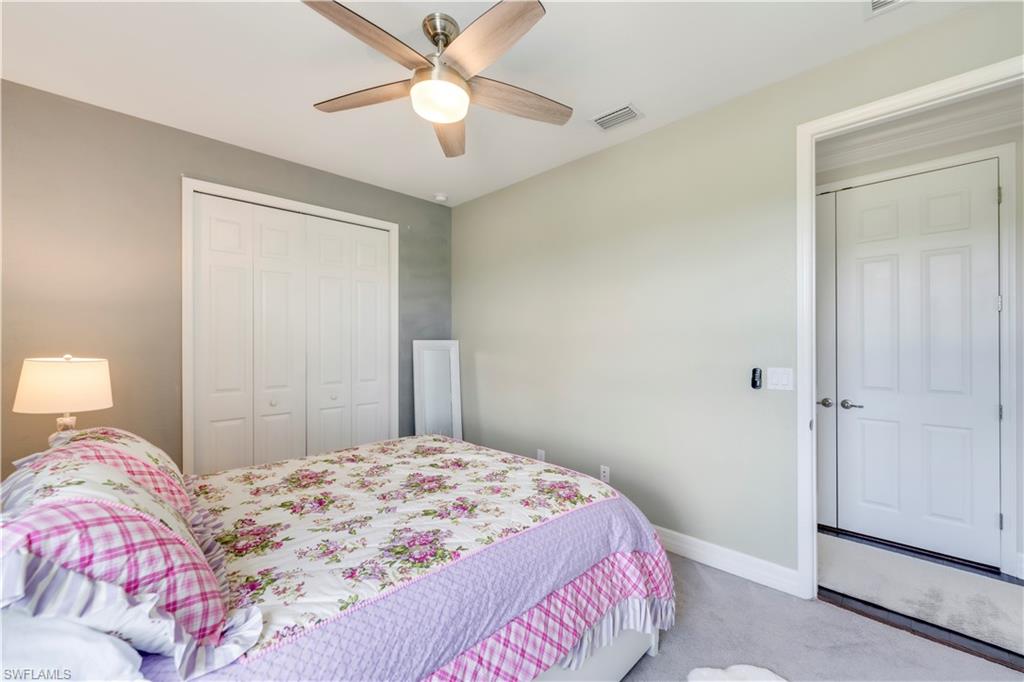 19128 Elston Way Estero, FL 33928 - Photo 31 of 50 a bedroom with a large bed and a chandelier