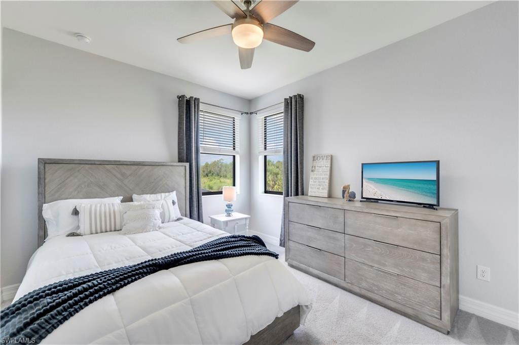 19128 Elston Way Estero, FL 33928 - Photo 32 of 50 a bedroom with a large bed and a chandelier