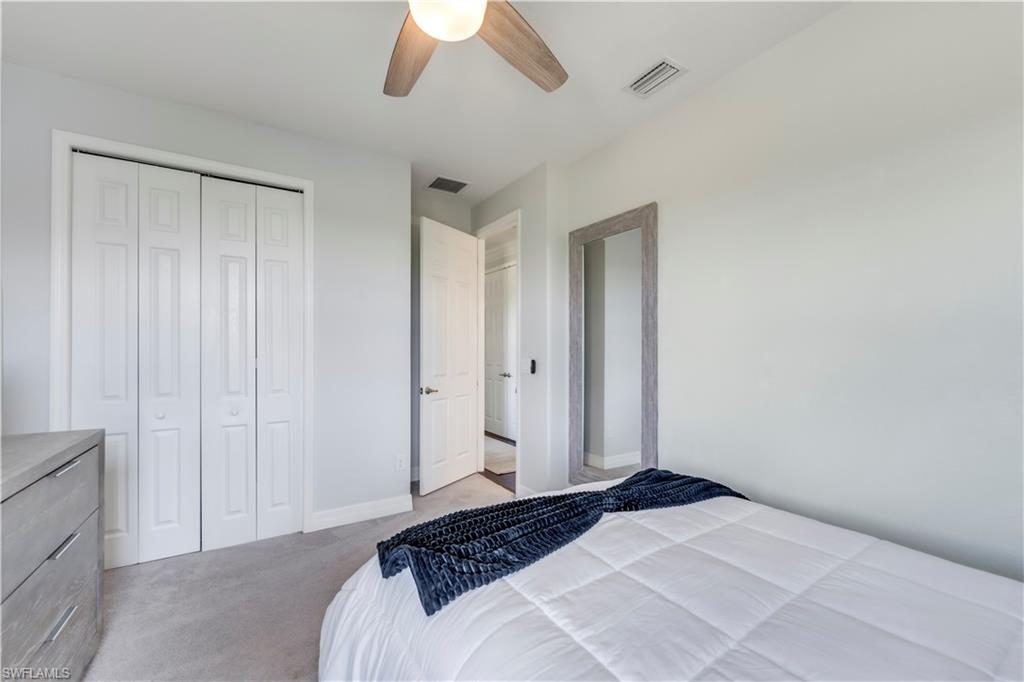 19128 Elston Way Estero, FL 33928 - Photo 33 of 50 a bedroom with a bed and a chandelier