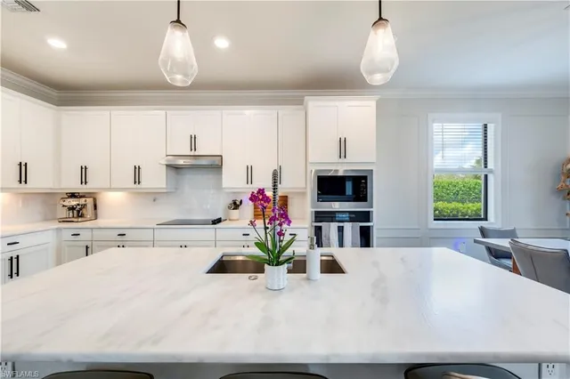 a kitchen with kitchen island granite countertop a sink a center island and stainless steel appliances