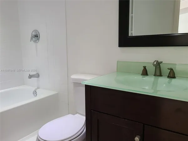a bathroom with a sink toilet vanity and bathtub