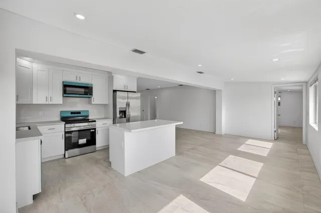 a kitchen with stainless steel appliances a sink cabinets and a stove top oven