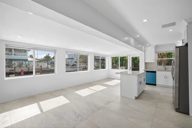 a view of kitchen with kitchen island stainless steel appliances cabinets and stove top oven