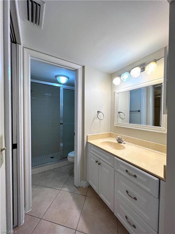 3471 County Barn Road, Unit F102 Naples, FL 34112 - Photo 12 of 19 a spacious bathroom with a granite countertop sink mirror and shower