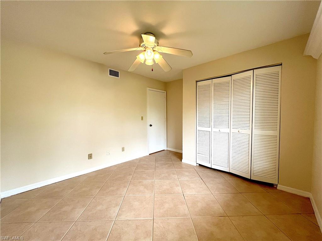 3471 County Barn Road, Unit F102 Naples, FL 34112 - Photo 14 of 19 an empty room with closet and a chandelier fan