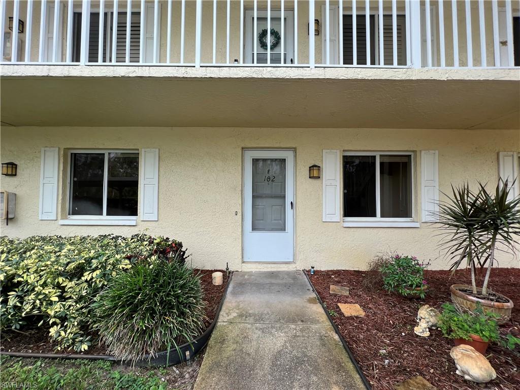 3471 County Barn Road, Unit F102 Naples, FL 34112 - Photo 18 of 19 a front view of a house with a garden