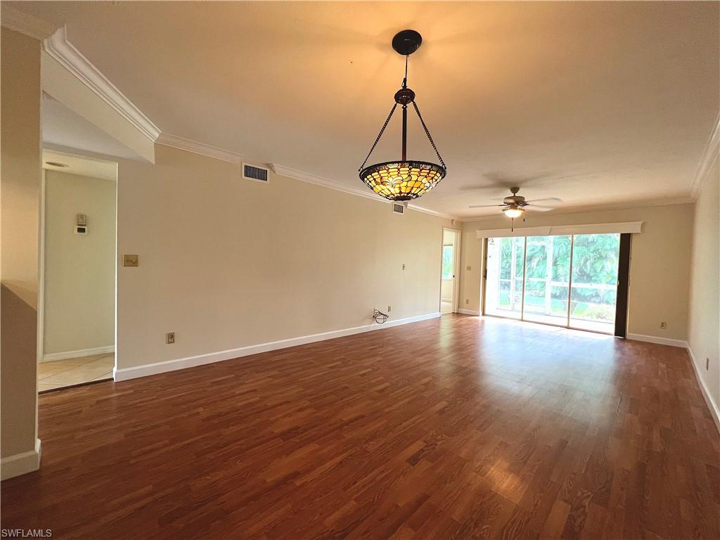 3471 County Barn Road, Unit F102 Naples, FL 34112 - Photo 6 of 19 a view of a room with wooden floor and chandelier