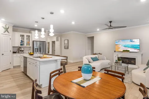 a view of a dining room with furniture a chandelier and wooden floor
