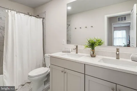 a bathroom with a sink a toilet and a mirror
