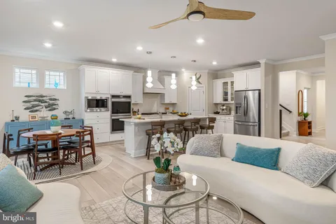 a living room with stainless steel appliances furniture and kitchen view