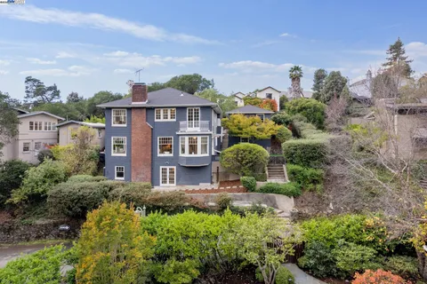 a view of a house with a big yard plants and large trees