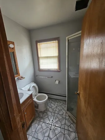 a bathroom with a granite countertop toilet and a sink