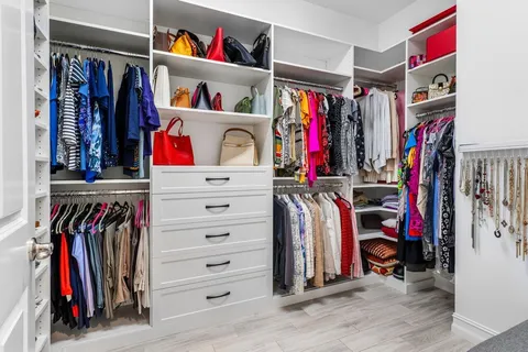 a view of walk in closet with clothes